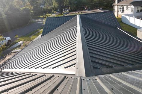 metal roof is installed to on an aframe house|metal roofing for homes.